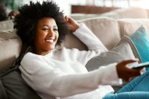 Shot of a young woman relaxing on the sofa at home and watching tv
